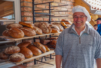 Bäcker Thomas Müller ist sehr glücklich nach dem Backen der ersten Brote im neuen Ofen