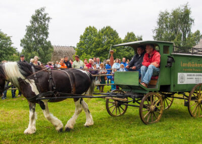 Ein alter Bäckerwagen wird von einem Pferd gezogen.