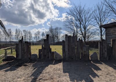 Ein aus Holzbalken und Feldsteinen gebauter Zaun zur Begrenzung des Gartens.